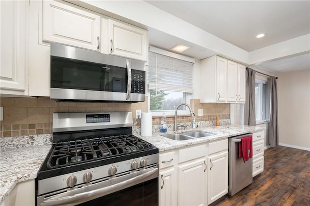 kitchen featuring white cabinetry, sink, dark wood-type flooring, backsplash, and appliances with stainless steel finishes