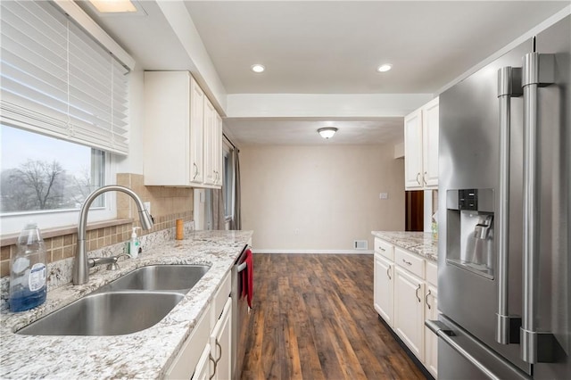 kitchen featuring sink, dark hardwood / wood-style flooring, light stone counters, white cabinetry, and stainless steel appliances