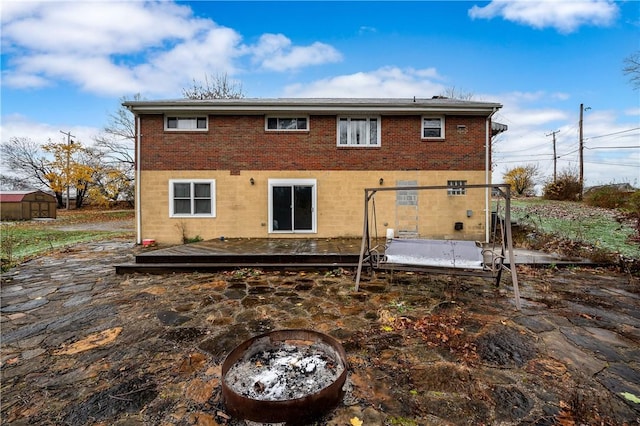 back of house featuring an outdoor fire pit