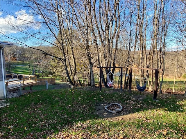 view of yard featuring a deck with water view and a fire pit