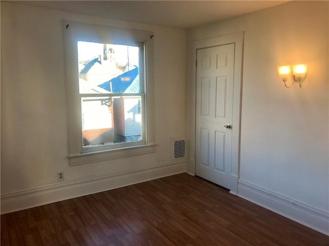 spare room with dark hardwood / wood-style flooring