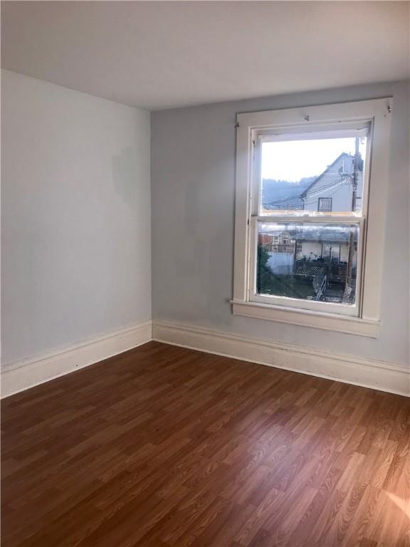 unfurnished room featuring dark wood-type flooring