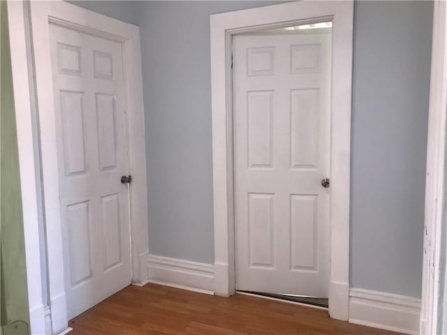 corridor with wood-type flooring