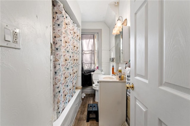 full bathroom with shower / bath combination with curtain, vaulted ceiling, toilet, vanity, and hardwood / wood-style flooring