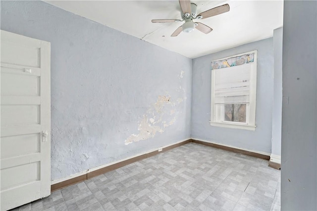empty room featuring tile patterned floors, ceiling fan, and baseboards