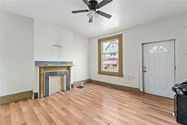 unfurnished living room featuring light wood finished floors, visible vents, baseboards, and a ceiling fan
