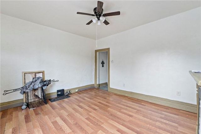 spare room featuring light wood-style flooring, ceiling fan, and baseboards