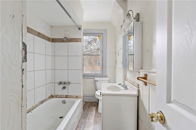 bathroom featuring toilet, shower / bath combination, wood finished floors, and vanity