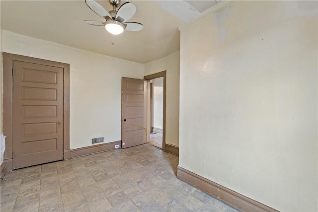 empty room featuring baseboards, a ceiling fan, and visible vents