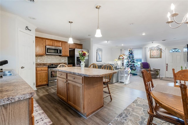 kitchen with appliances with stainless steel finishes, dark hardwood / wood-style floors, and a healthy amount of sunlight