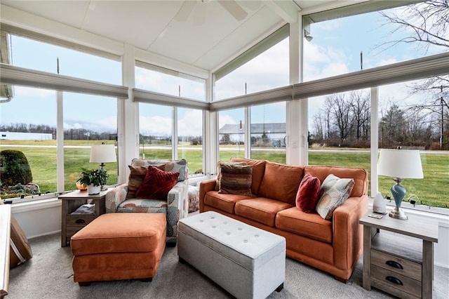 sunroom featuring lofted ceiling with beams, ceiling fan, and a healthy amount of sunlight