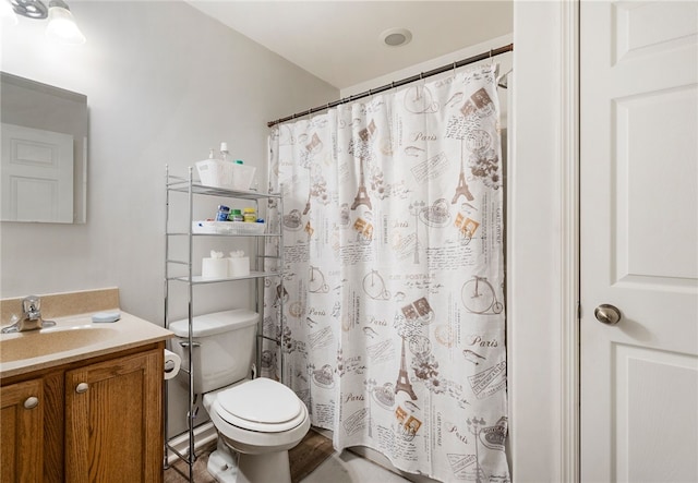 bathroom with walk in shower, vanity, and toilet