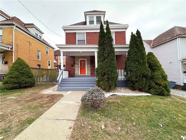 view of property featuring a porch and a front yard