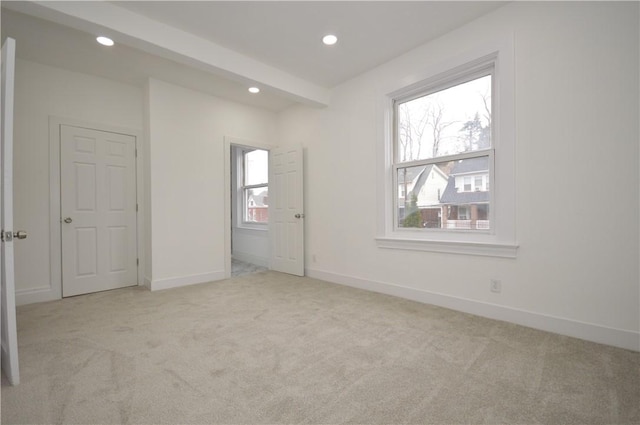 carpeted spare room featuring a healthy amount of sunlight