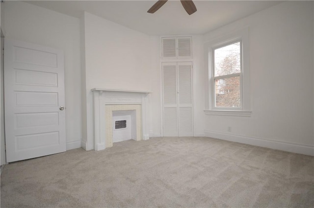 unfurnished living room featuring ceiling fan, a fireplace, and light carpet