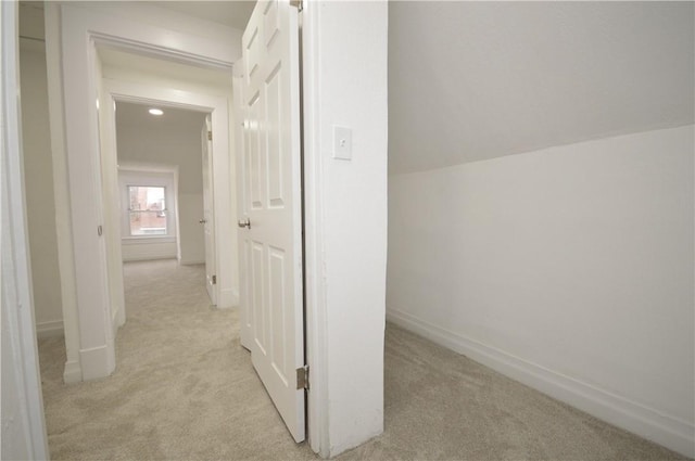 hall featuring light colored carpet and vaulted ceiling