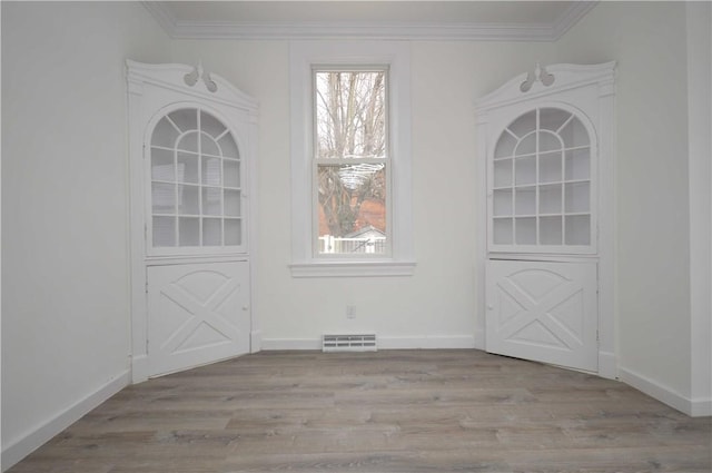 unfurnished dining area with light hardwood / wood-style floors, crown molding, and a wealth of natural light