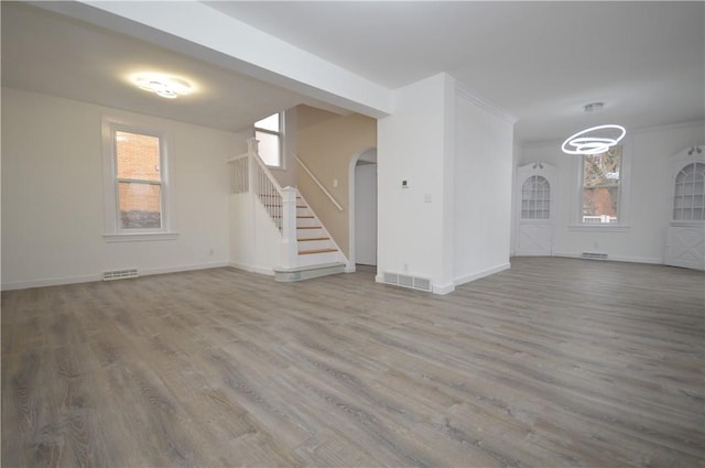 unfurnished living room featuring hardwood / wood-style floors and plenty of natural light