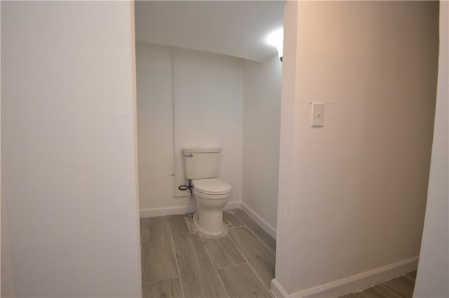 bathroom featuring wood-type flooring and toilet