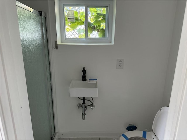 bathroom featuring toilet and an enclosed shower