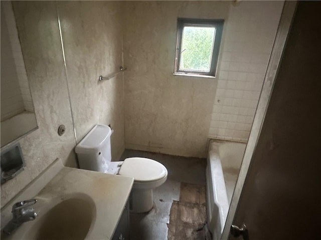 bathroom with tile patterned floors, a washtub, toilet, and vanity