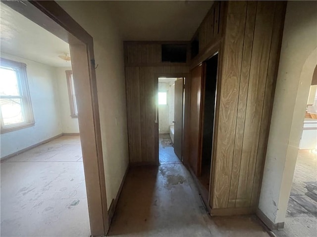 corridor featuring wood walls