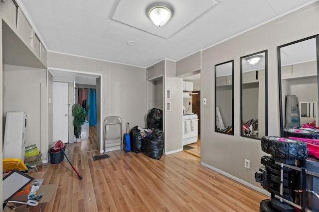 exercise room with light wood-type flooring