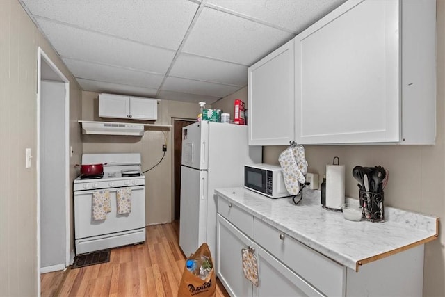 kitchen featuring white appliances, white cabinetry, a drop ceiling, and light hardwood / wood-style flooring