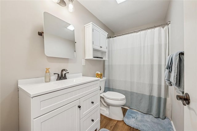 bathroom with toilet, vanity, and hardwood / wood-style flooring