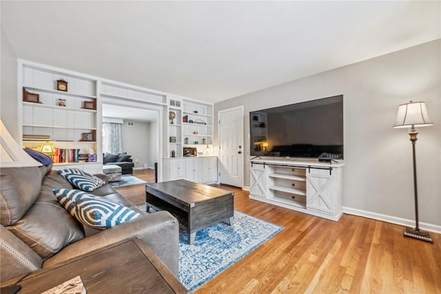 living room with hardwood / wood-style floors and built in features