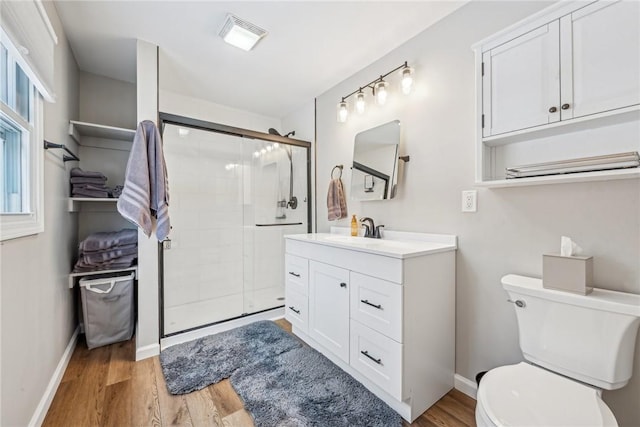 bathroom featuring an enclosed shower, vanity, toilet, and wood-type flooring