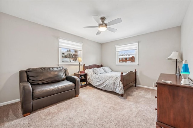 bedroom with multiple windows, ceiling fan, and light colored carpet