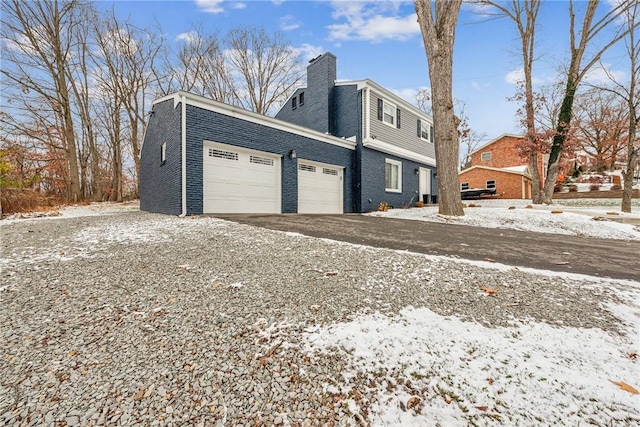 snow covered property featuring a garage