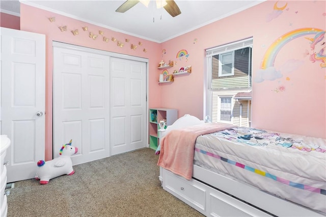 bedroom with ceiling fan, crown molding, light carpet, and a closet