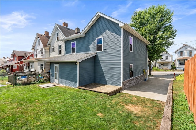 rear view of property with a lawn