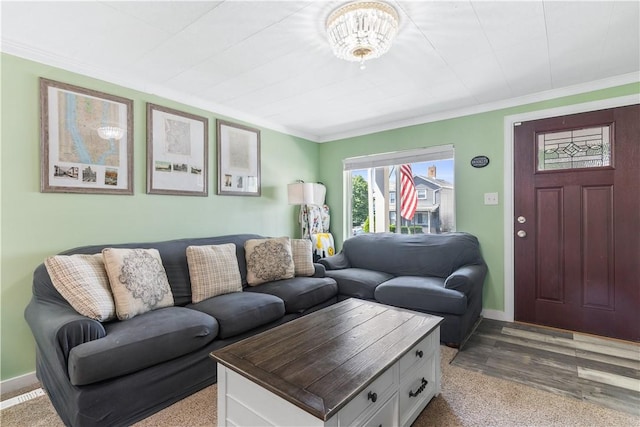 living room with a notable chandelier, light wood-type flooring, and ornamental molding