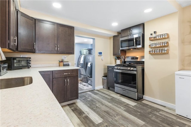 kitchen featuring hardwood / wood-style flooring, dark brown cabinets, and appliances with stainless steel finishes