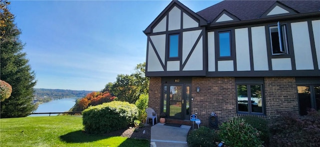 exterior space featuring a lawn and a water view