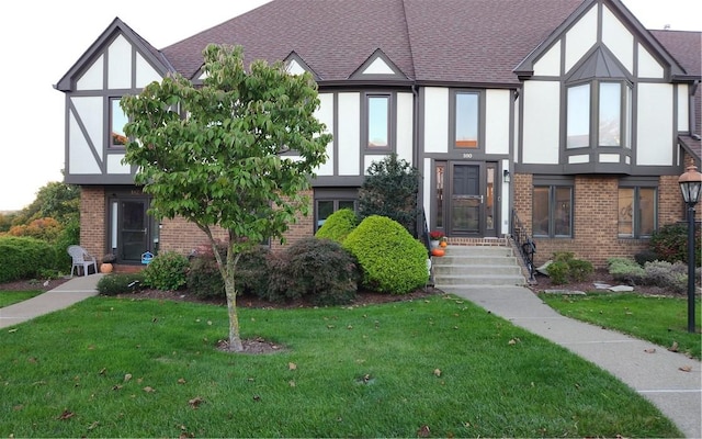 tudor-style house with a front yard