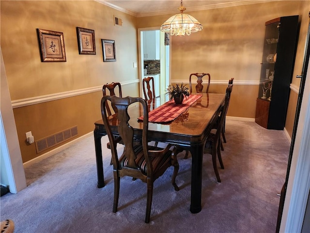 carpeted dining area featuring crown molding and a notable chandelier