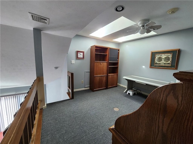 carpeted home office with a skylight and ceiling fan