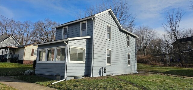 view of side of property featuring a yard and a sunroom