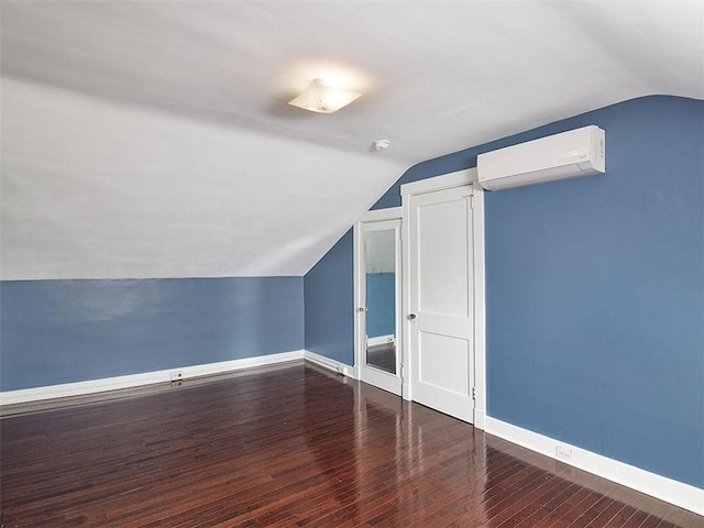 bonus room with an AC wall unit, vaulted ceiling, and dark hardwood / wood-style floors