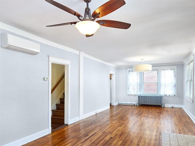 unfurnished room with radiator, ornamental molding, a wall mounted AC, ceiling fan, and wood-type flooring