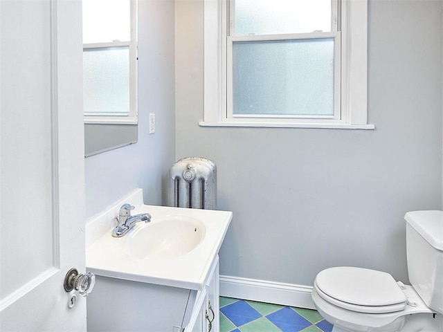 bathroom featuring vanity, toilet, and radiator heating unit