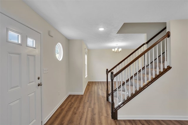 foyer entrance with a chandelier and dark wood-type flooring