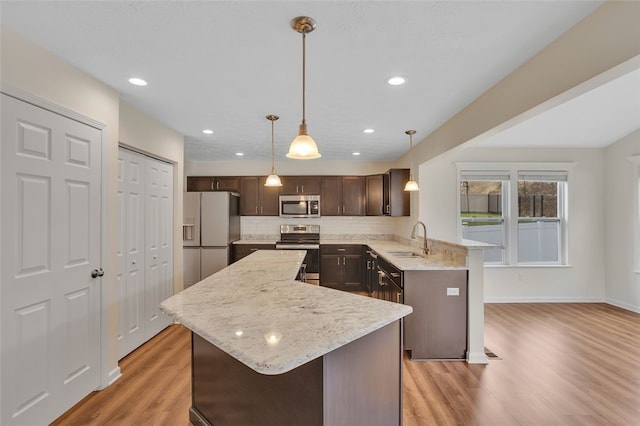 kitchen featuring appliances with stainless steel finishes, light hardwood / wood-style floors, dark brown cabinets, and sink