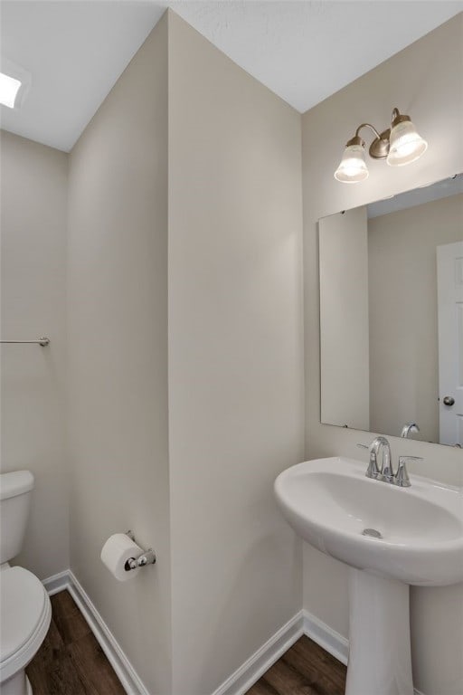 bathroom with hardwood / wood-style flooring and toilet