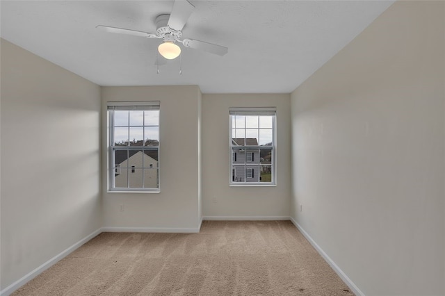 carpeted spare room with ceiling fan