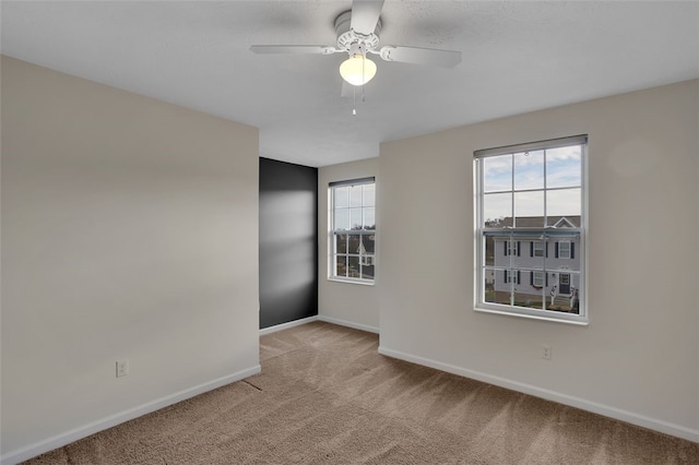 carpeted empty room featuring ceiling fan